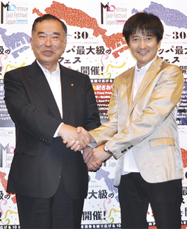 握手を交わす山田委員長（左）と本田さん
