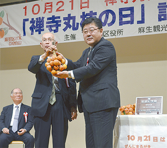 水野会長（中央）から多田区長（右）に今年収穫された禅寺丸柿が贈呈された