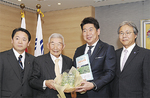 のらぼう菜を福田市長に贈呈する保存会の高橋会長（左から２人目）