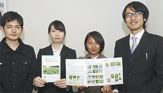 柘植さん（右）、栽培マニュアルを手にする溝田さん（右から３人目）ら明大生＝２月28日、市庁舎