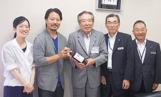 原代表理事組合長（右から3人目）に川崎産ワインを手渡すカルナエストの山田代表（同4人目）
