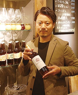 山田さんが手にするのは市内初、岡上で収穫したブドウで醸造した特製ワイン