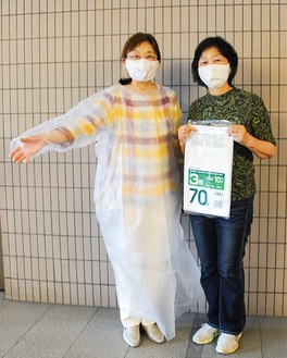 ごみ袋で作ったガウンを着る門平きょう子さん(左)と藤岡たか子さん