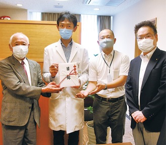 菅泰博病院長（左から２人目）に目録を手渡す蓬田忠会長（左）