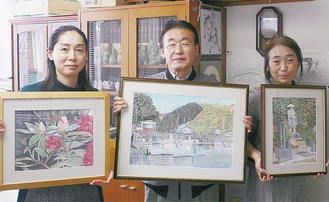 祥三さんの絵を持つ寺尾社長（中央）と社員