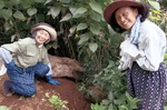 生ごみ堆肥を入れた土に触れる松下さん（左）と島貫さん