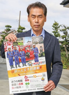 火災予防週間のポスターを手にする土方会長