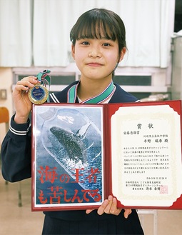 賞状と記念のメダルをもつ平野さん