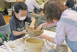 粘土の形を整える参加者