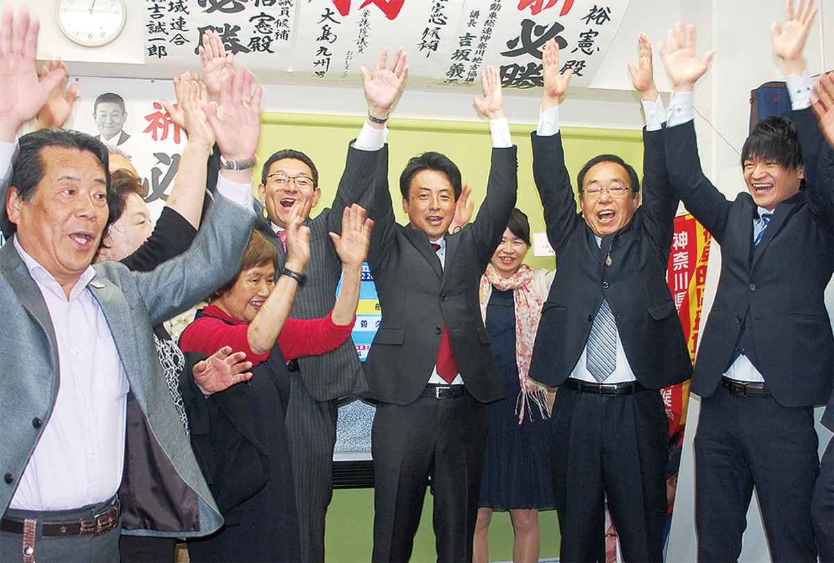 支援者と喜ぶ石川氏（中央）