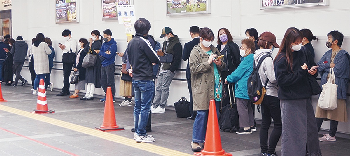 かわさききたテラス前で販売開始を待つ人たち＝19日午前9時50分