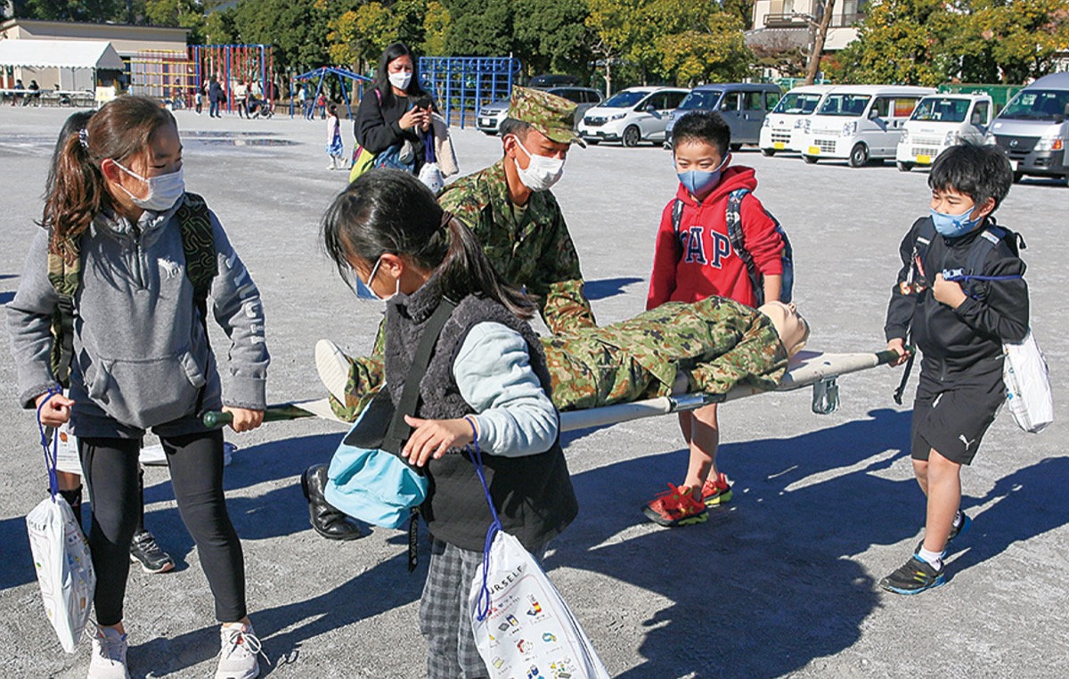 担架で搬送体験をする子どもたち