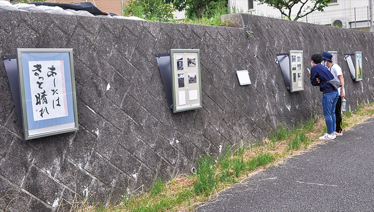 作品を見学する通行者