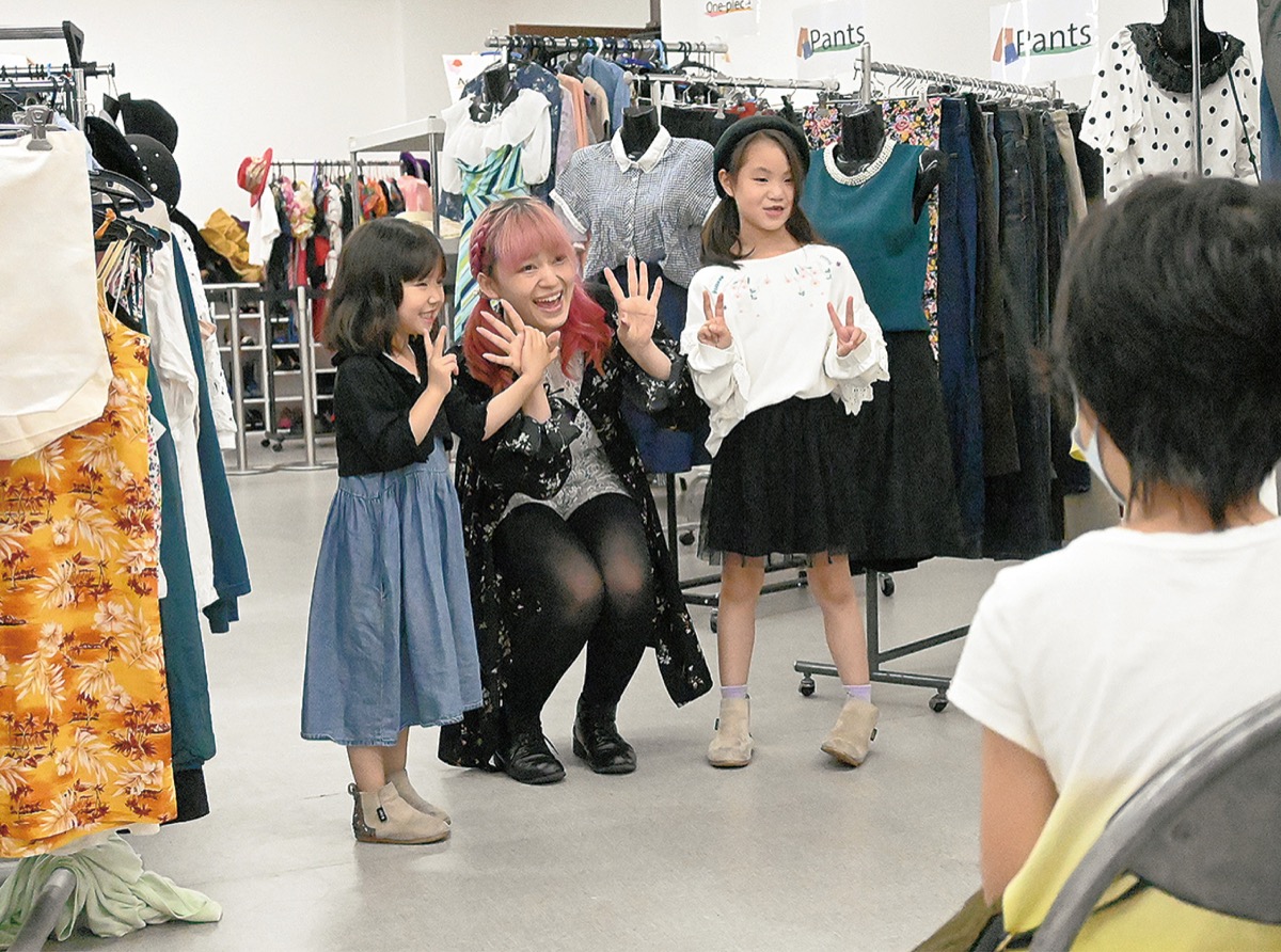 大人と子どもがランウェイを歩いて服を披露