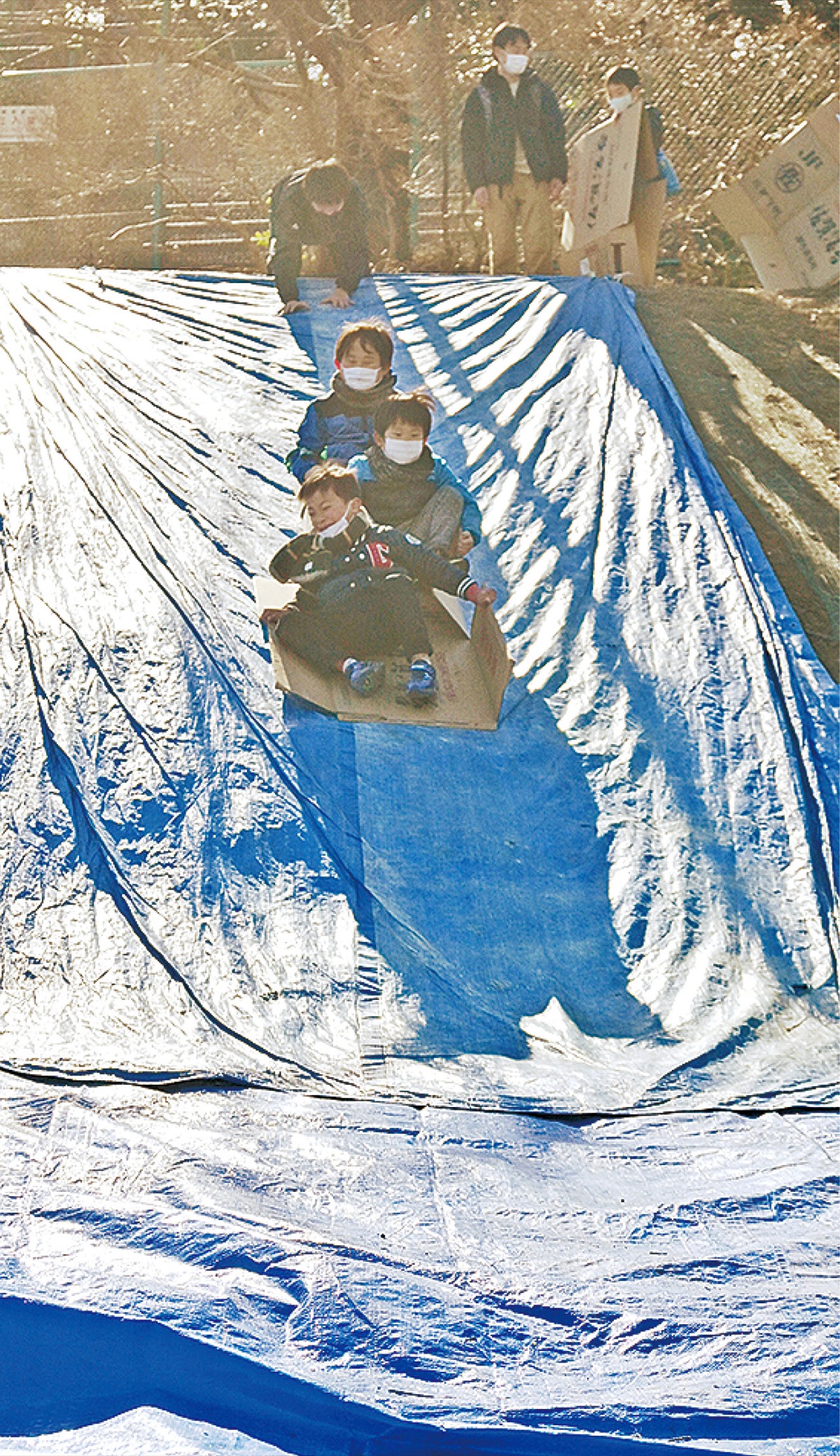 傾斜地を生かしたすべり台で遊ぶ子どもたち