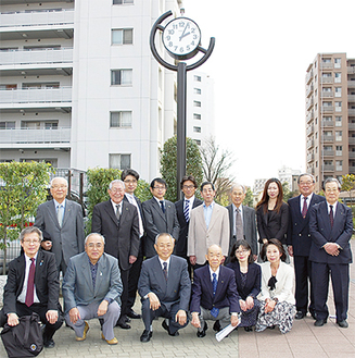 寄贈した時計の前に立つ川崎多摩川ＬＣのメンバーと地域住民