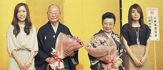 孫の斎藤友香理さん（左端）、里沙子さん（右端）から花束を受けとった斎藤文夫さんと富美子夫人