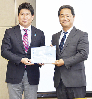 福田市長（左）に報告書を手渡す渡邉代表取締役