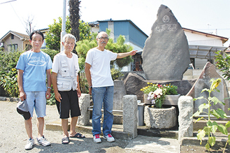 慰霊碑の前に立つ千吉良さん、荻田昌昭さん、荻田昇さん（右から）
