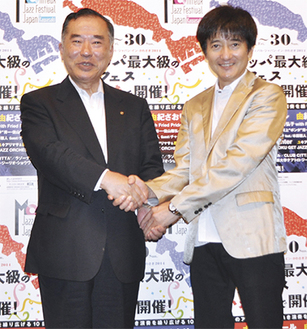 握手を交わす山田委員長（左）と本田さん