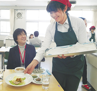 自信たっぷりの料理を運び、笑顔で教員をもてなす生徒