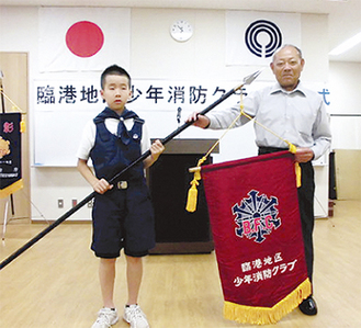 クラブ旗を受け取る高橋隆平さん（左）