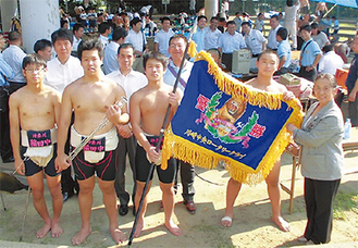 優勝旗を手にする諏訪部さん（中央）と中村会長（右）