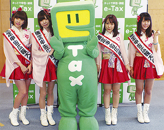 国税電子申告・納税システム（e-Tax）のキャラクター「イータ君」と並ぶ、この日出席した川崎純情小町☆のメンバー