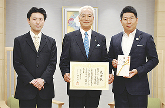 感謝状を手にする畔蒜社長（中央）と石黒店長（左）、目録を受け取った福田市長