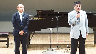 報告のためステージに立つ桜井市長（左）