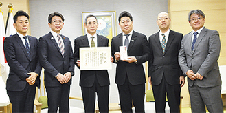 福田市長（右3番目）を囲んで記念写真に納まる綱島委員長（同4番目）ら同組合メンバー
