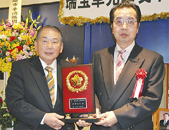 記念品を受け取った金澤さん（左）と上田常晴副団長