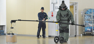 模擬の爆発物を処理する機動隊員