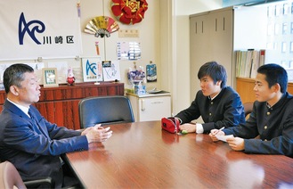 川崎区長に取材する赤星さん（中央）と朝倉さん（右）