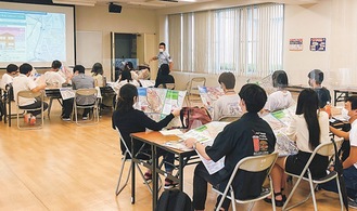 各区のハザードマップを手に幸消防署員の話に耳を傾ける参加者ら＝那須野さん提供