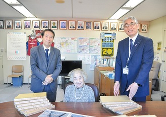 アルバムを前に記念写真に納まる木村さん、所さん、増田宏之区長(左から)