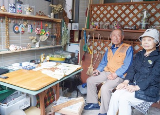 ガレージの工房で大沢さんと師匠の石田さん（左から）
