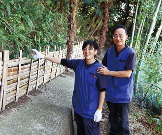 手作りで整備した竹の柵の前に立つ中島大助さん（右）と竹田一樹さん