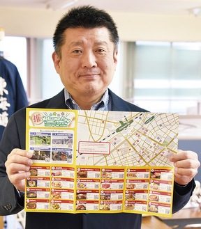 川崎駅前のグルメマップを持つ吉澤さん