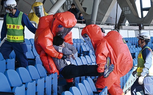 防護服を着て搬送する消防署員