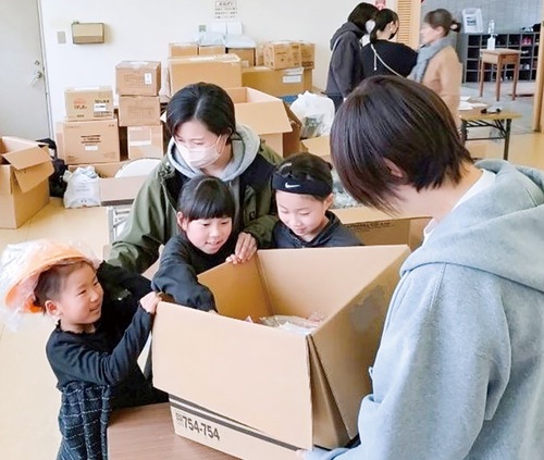 学用品を受け取る子どもたち＝市提供