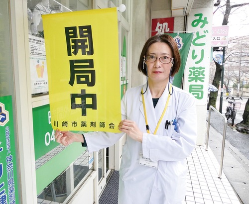 営業を示す旗を持つ佐々木さん