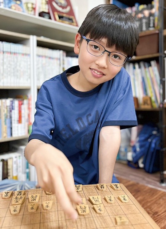 将棋盤上にある駒を動かす黒松さん