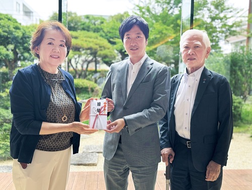 目録を手にする関係者