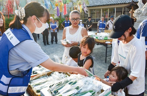 看護大生からきゅうりを受け取る子ども