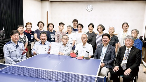 寄贈した卓球台を囲んで記念写真に納まる関係者