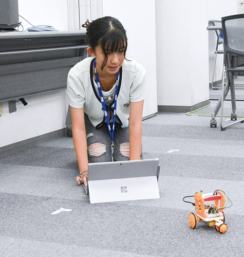 パソコンでロボットを操作する高田さん
