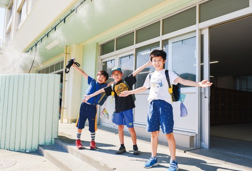 ミストシャワーを浴びる幸町小学校の児童ら