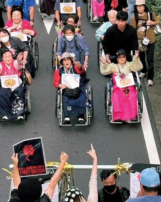 ラップ調のコールに合わせて手を振るハルモニたち