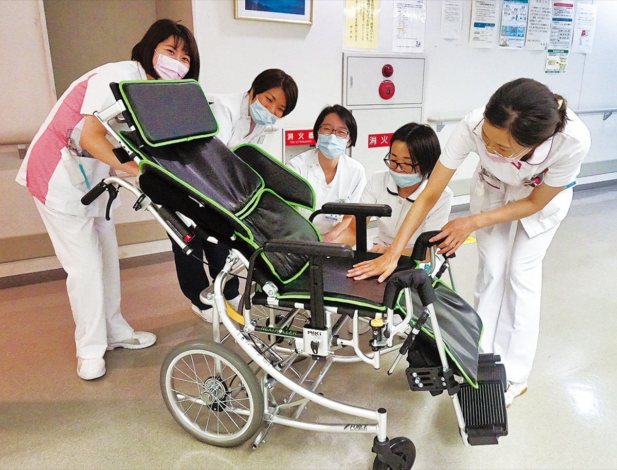 贈られた車いすに見入る同病院職員